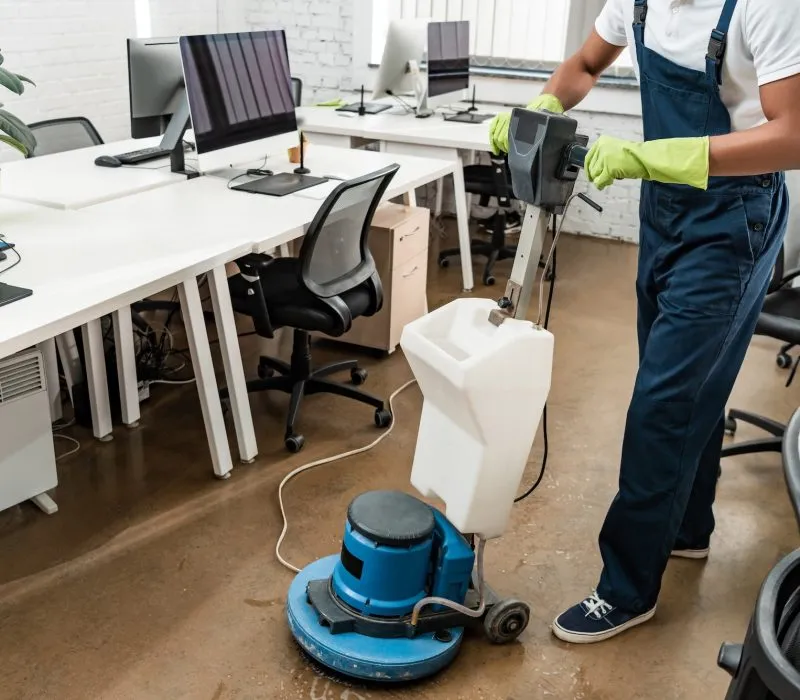 partial view of african amercan cleaner washing floor with cleaning machine